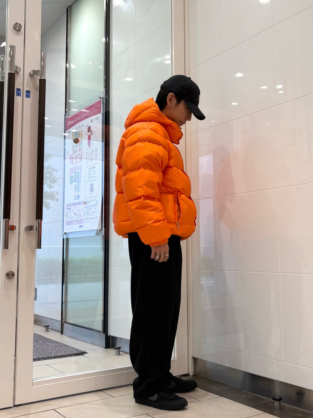 レッド系のダウンジャケット/コート、ブラック系のその他パンツ、ブラック系のキャップを着用したメンズの秋コーディネートの4枚目の写真