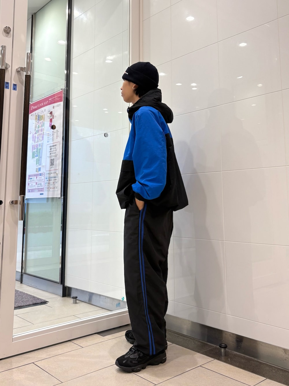 ブルー系のナイロンジャケット、ブルー系のその他パンツ、ブラック系のスニーカーを着用したメンズの秋コーディネートの3枚目の写真