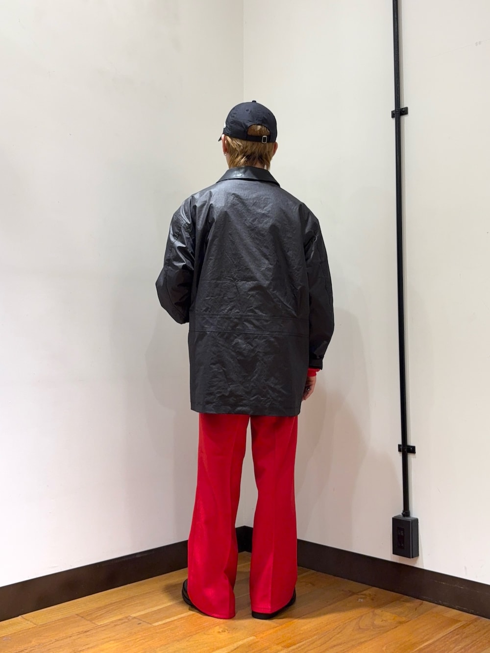 ブラック系のその他アウター、レッド系のその他パンツ、レッド系のニット/セーターを着用したメンズの冬コーディネートの3枚目の写真