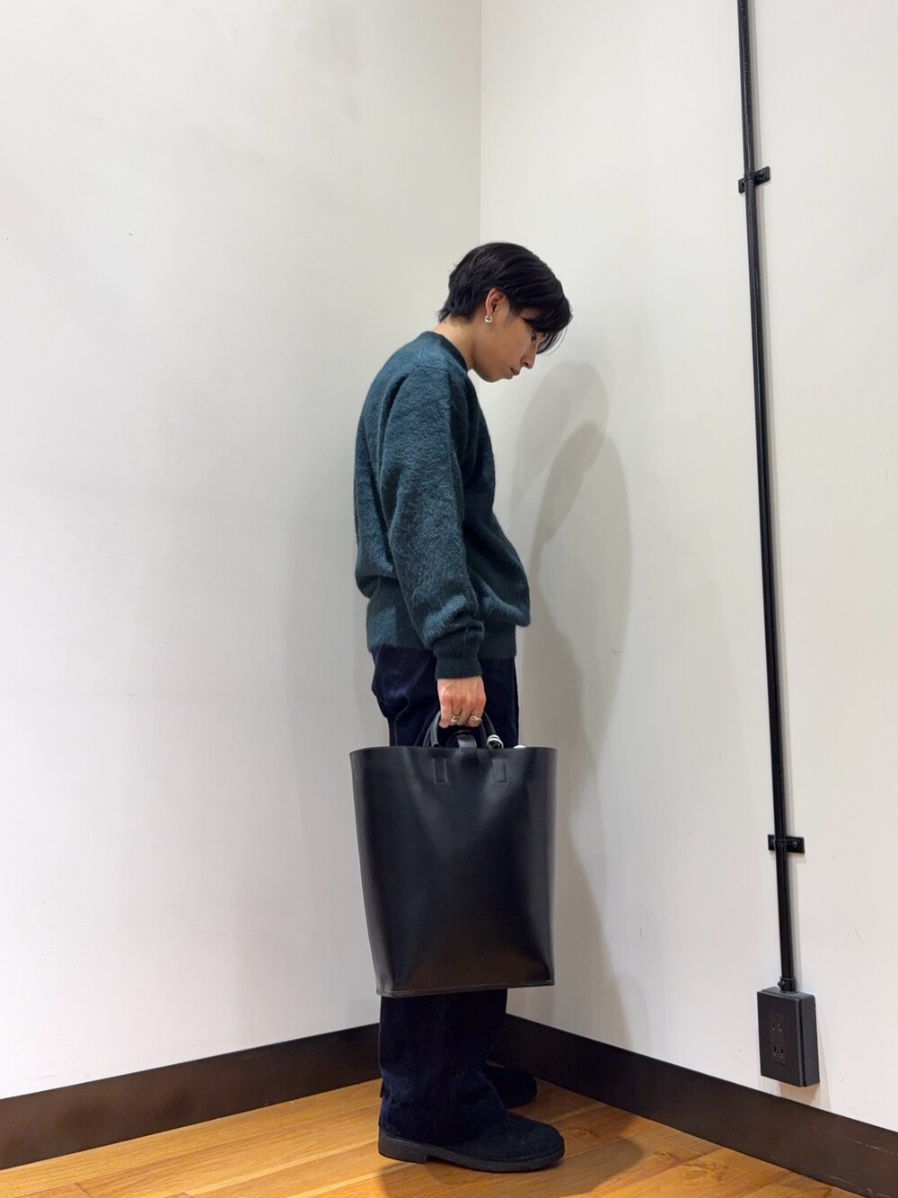 グリーン系のニット/セーター、グレー系のその他パンツ、ブラック系のトートバッグを着用したメンズの秋コーディネートの4枚目の写真