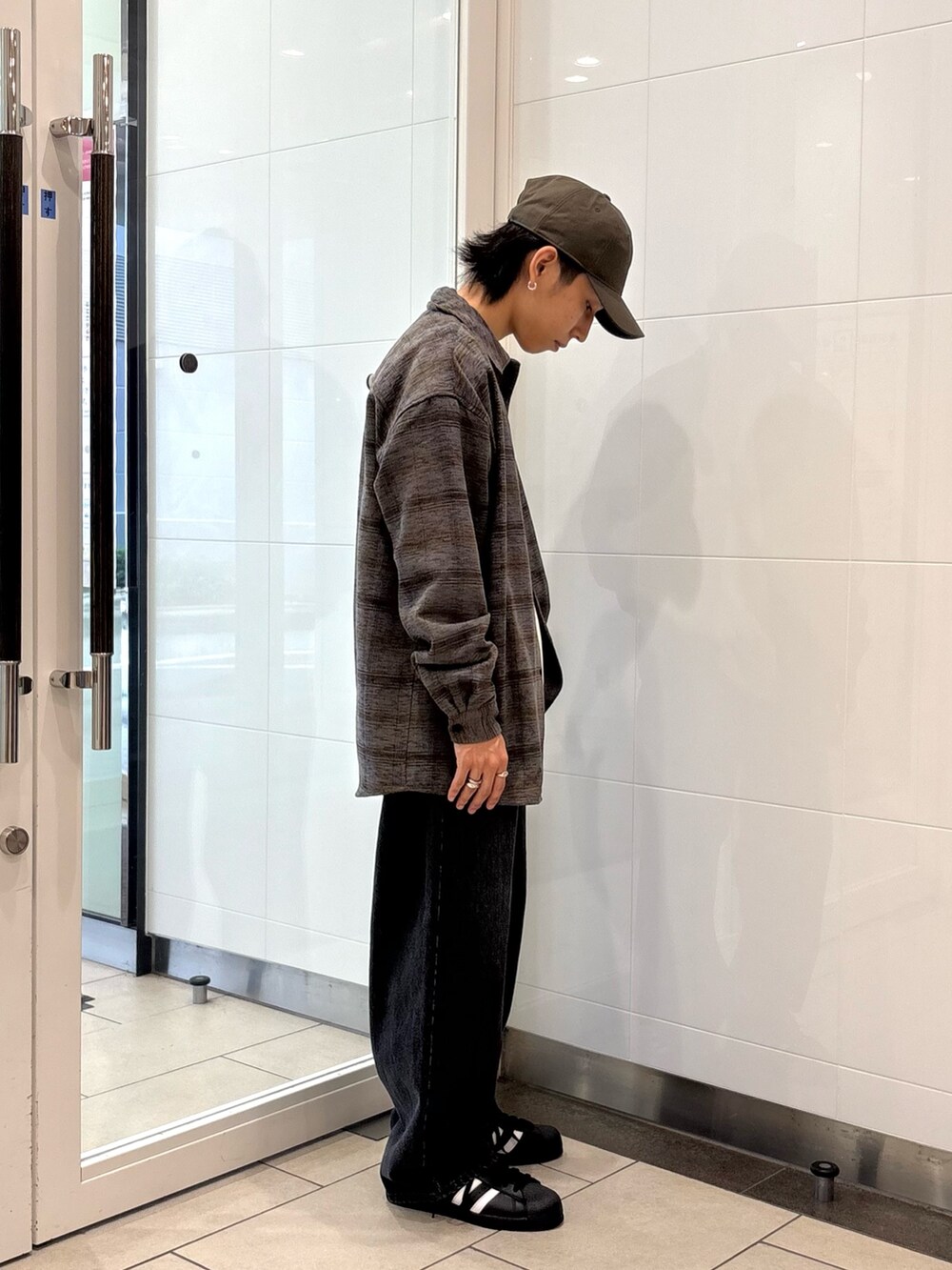 グレー系のシャツ/ブラウス、ベージュ系のTシャツ/カットソー、ブラック系のデニムパンツを着用したメンズの秋コーディネートの4枚目の写真