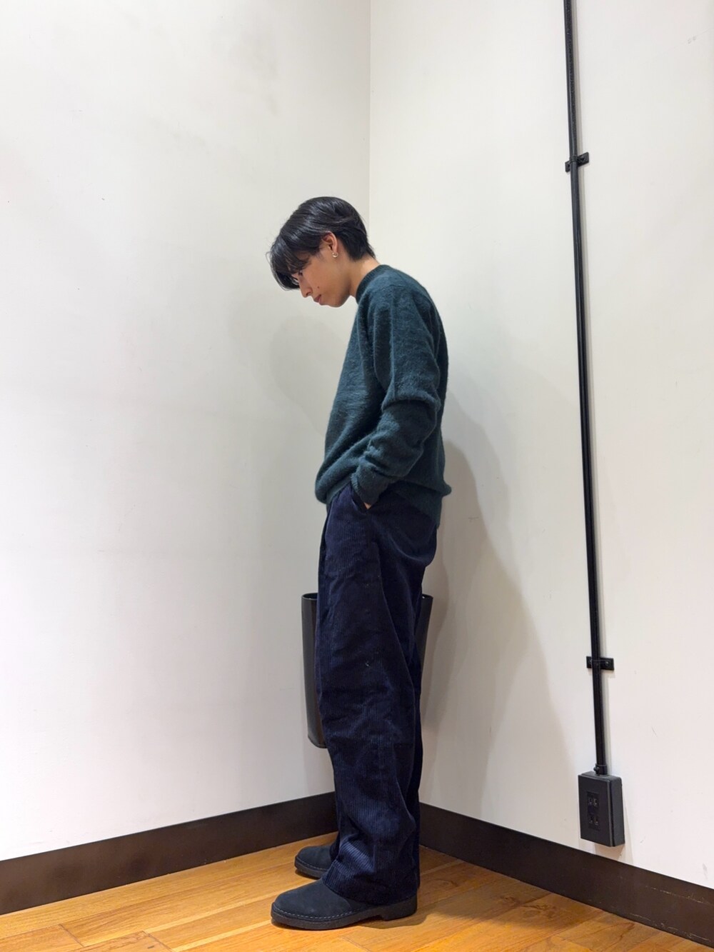 グリーン系のニット/セーター、グレー系のその他パンツ、ブラック系のトートバッグを着用したメンズの秋コーディネートの2枚目の写真