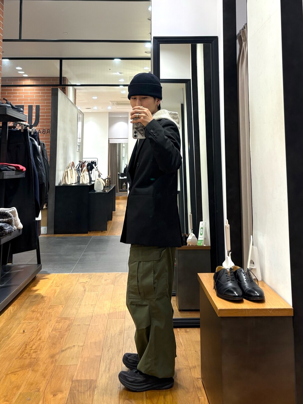 グリーン系のその他アウター、グレー系のパーカー、ブラック系のニットキャップ/ビーニーを着用したメンズの冬コーディネートの2枚目の写真