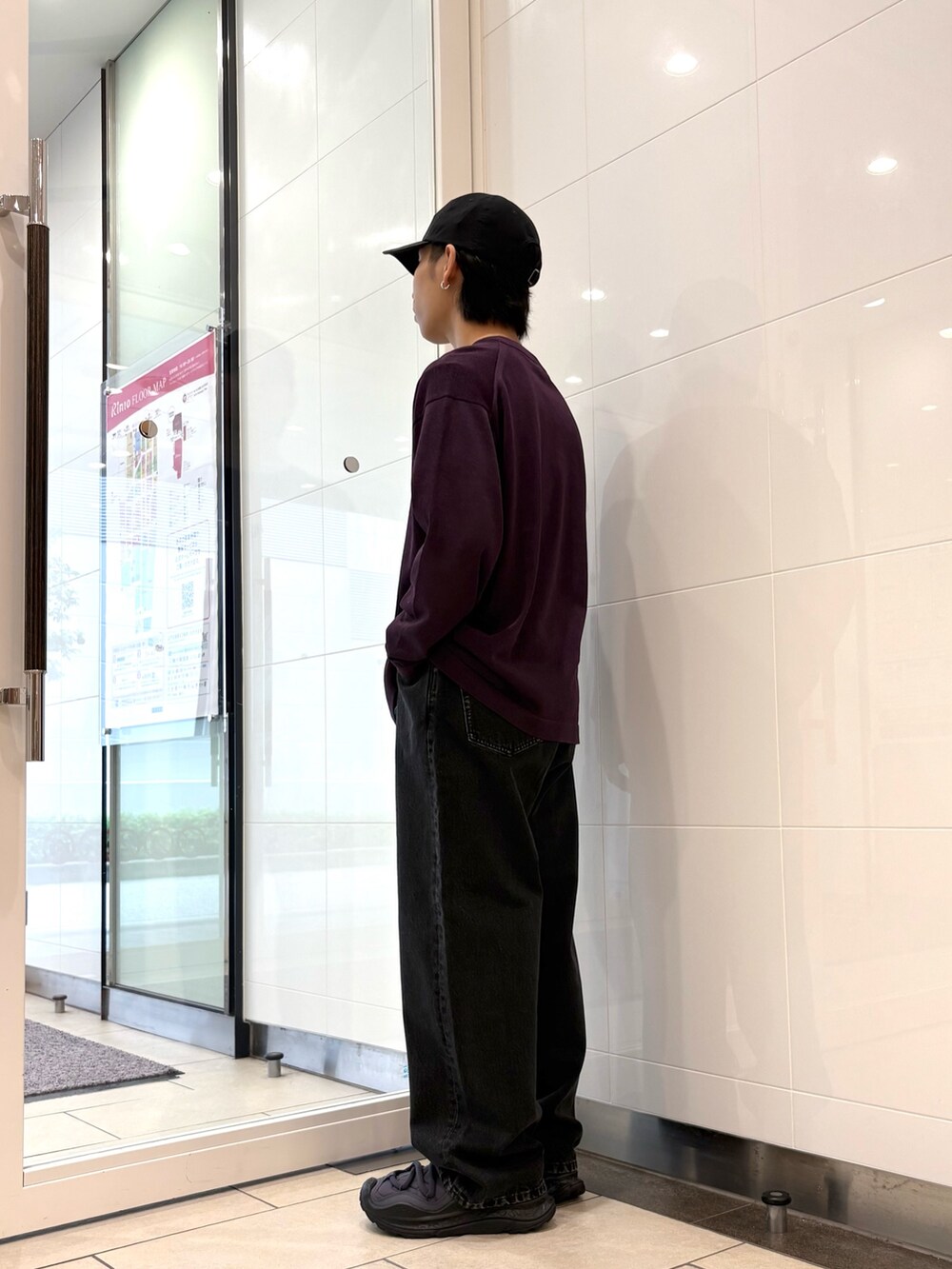 パープル系のニット/セーター、ブラック系のデニムパンツ、ブラック系のスニーカーを着用したメンズの秋コーディネートの2枚目の写真