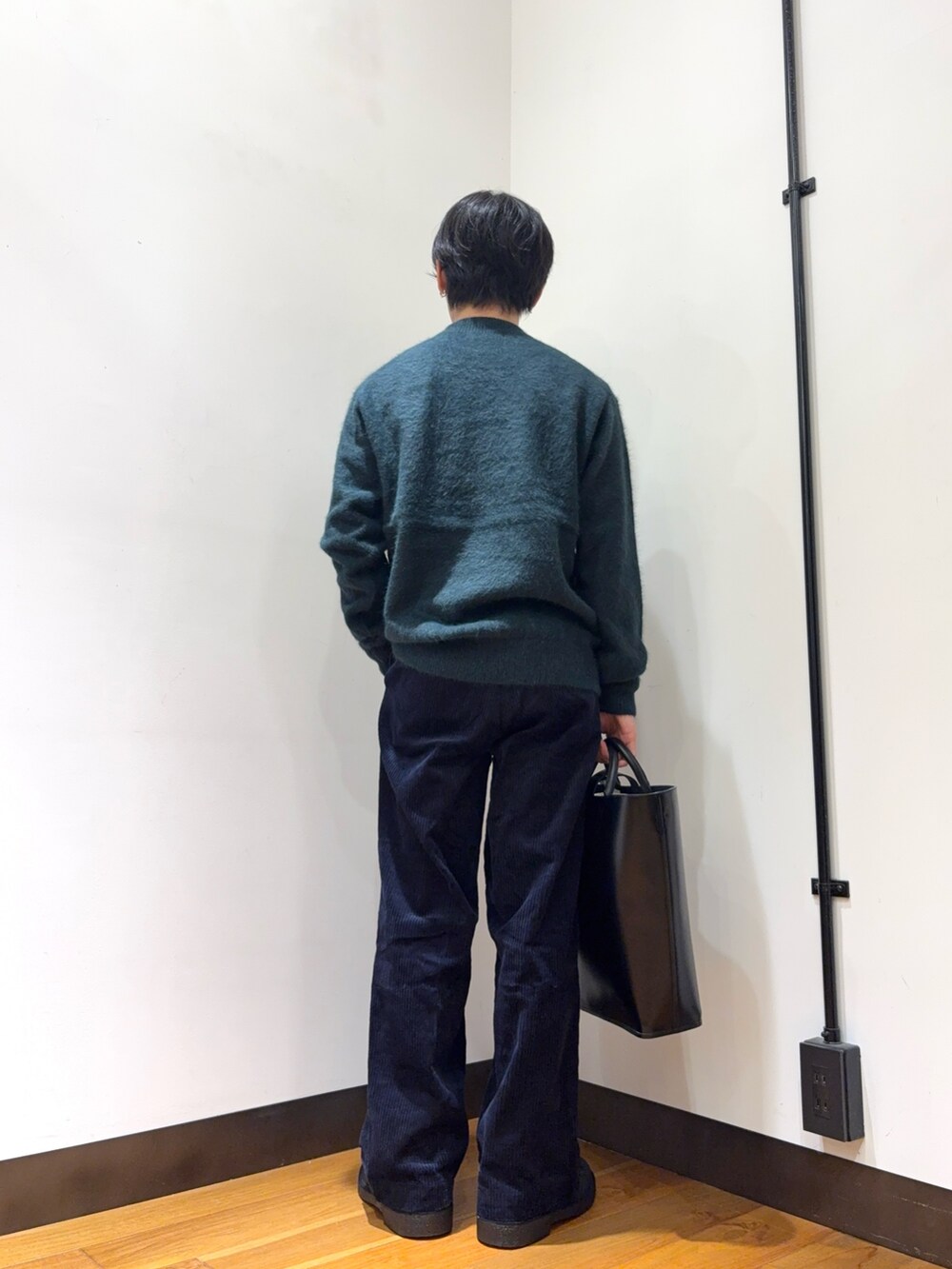 グリーン系のニット/セーター、グレー系のその他パンツ、ブラック系のトートバッグを着用したメンズの秋コーディネートの3枚目の写真