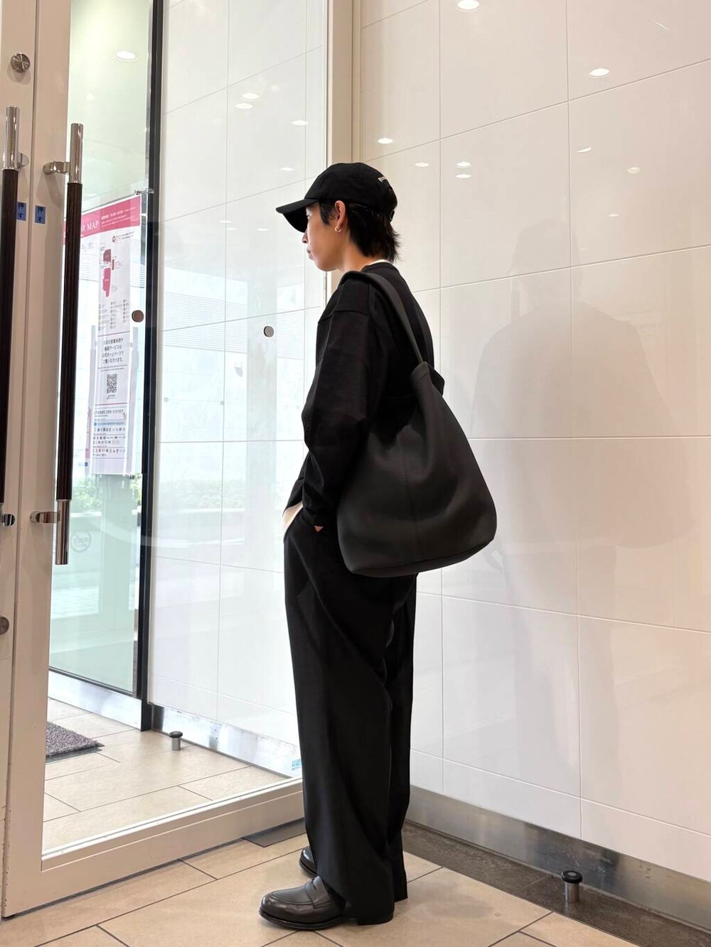 ブラック系のトートバッグ、ブラック系のニット/セーター、ブラック系のその他パンツを着用したメンズの夏コーディネートの2枚目の写真