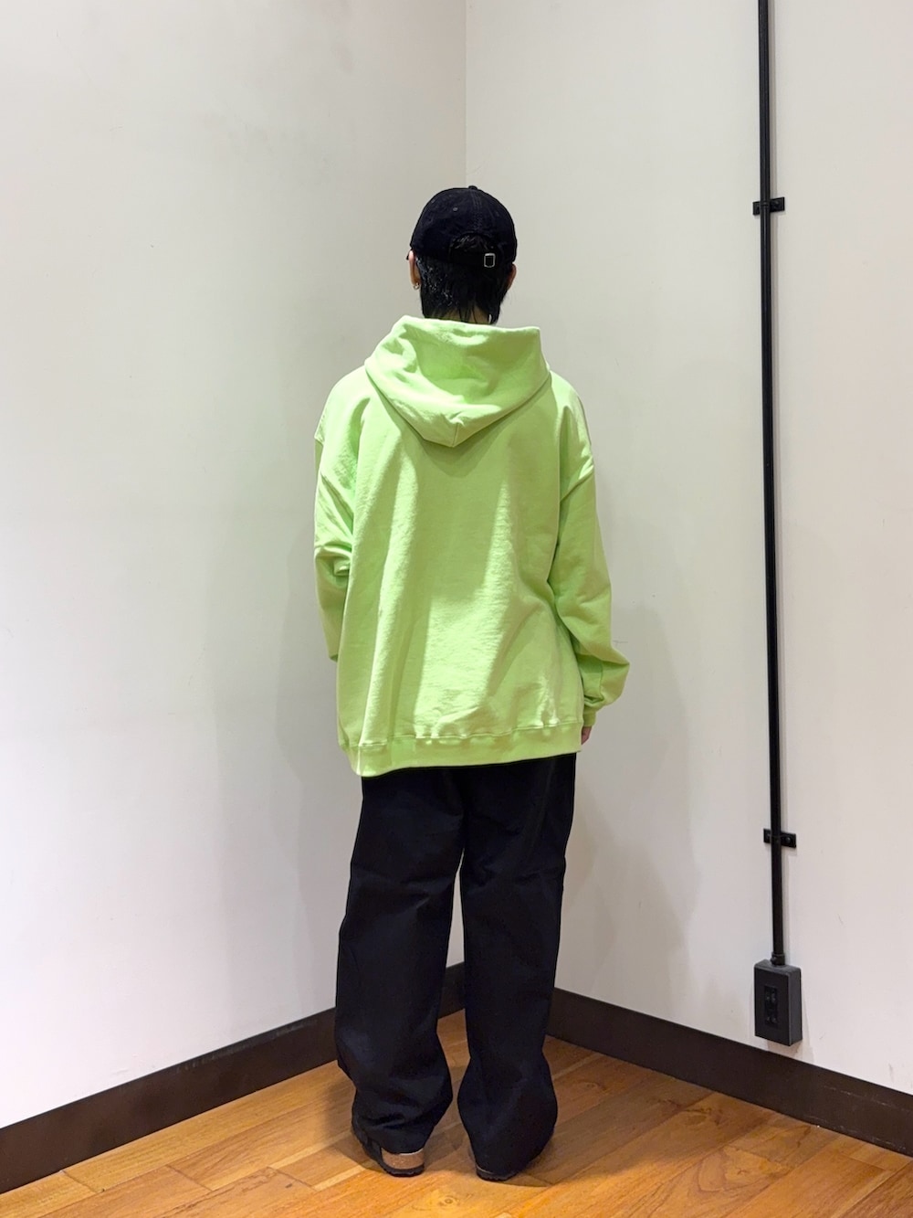 グリーン系のパーカー、ブラック系のその他パンツ、ブラック系のサンダルを着用したメンズの秋コーディネートの3枚目の写真