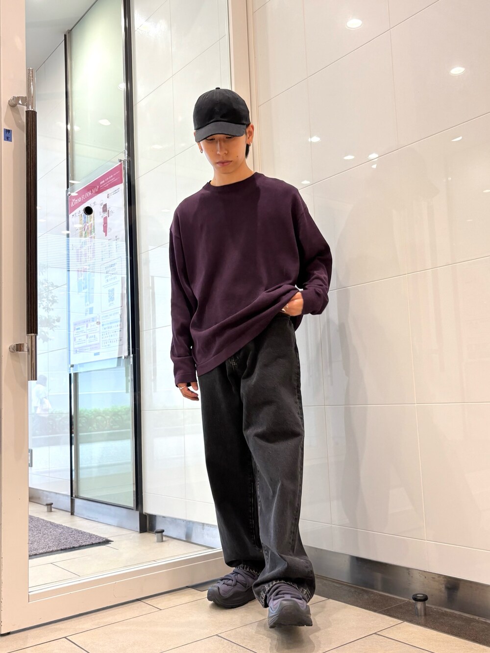 パープル系のニット/セーター、ブラック系のデニムパンツ、ブラック系のスニーカーを着用したメンズの秋コーディネートの5枚目の写真