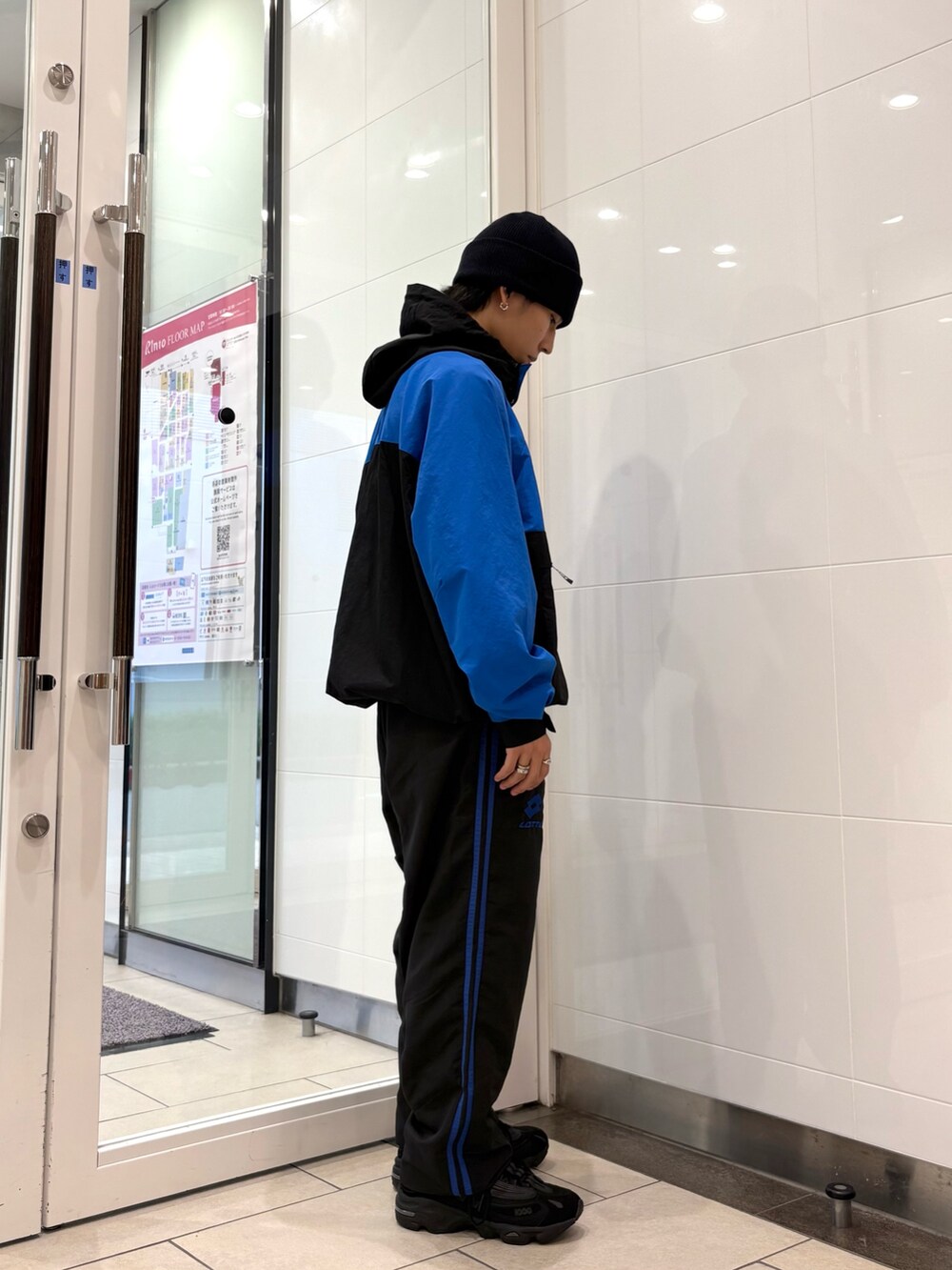 ブルー系のナイロンジャケット、ブルー系のその他パンツ、ブラック系のスニーカーを着用したメンズの秋コーディネートの5枚目の写真