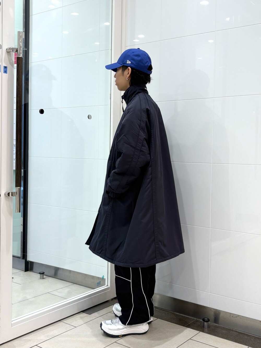 ブルー系のダウンジャケット/コート、ブラック系のその他パンツ、ホワイト系のスニーカーを着用したメンズの秋コーディネートの2枚目の写真