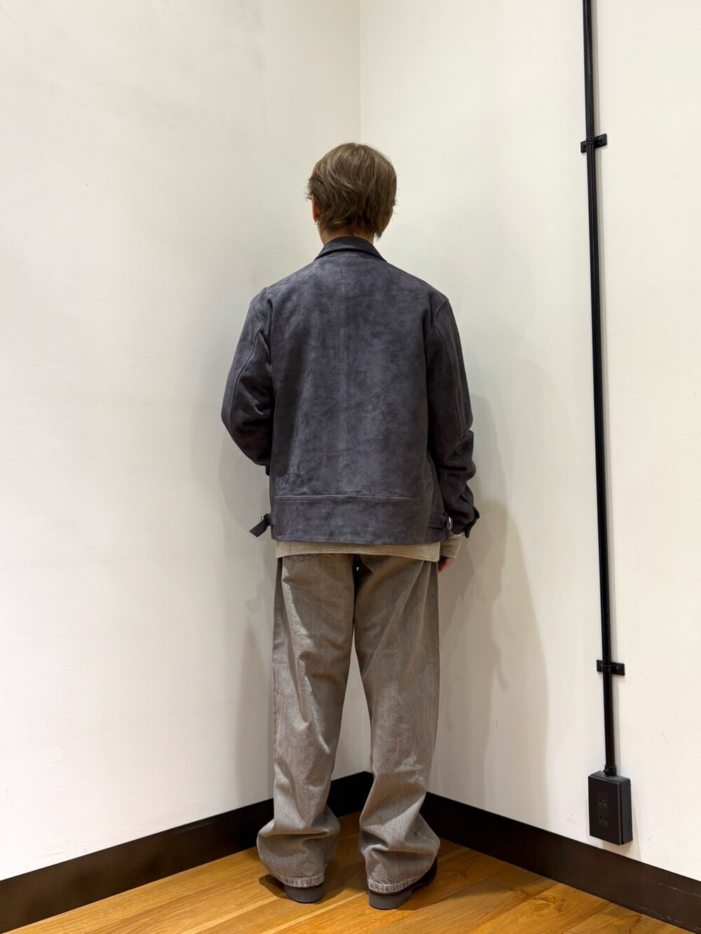 グレー系のブルゾン、グレー系のスウェット、ブラウン系のデニムパンツを着用したメンズの冬コーディネートの3枚目の写真