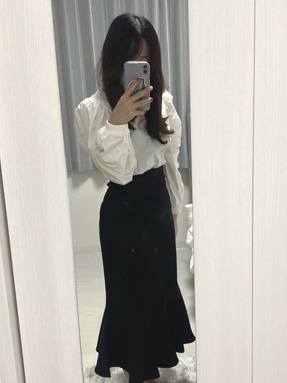 ブラック系のスカート、ホワイト系のシャツ/ブラウスを着用したレディースの秋コーディネートの3枚目の写真