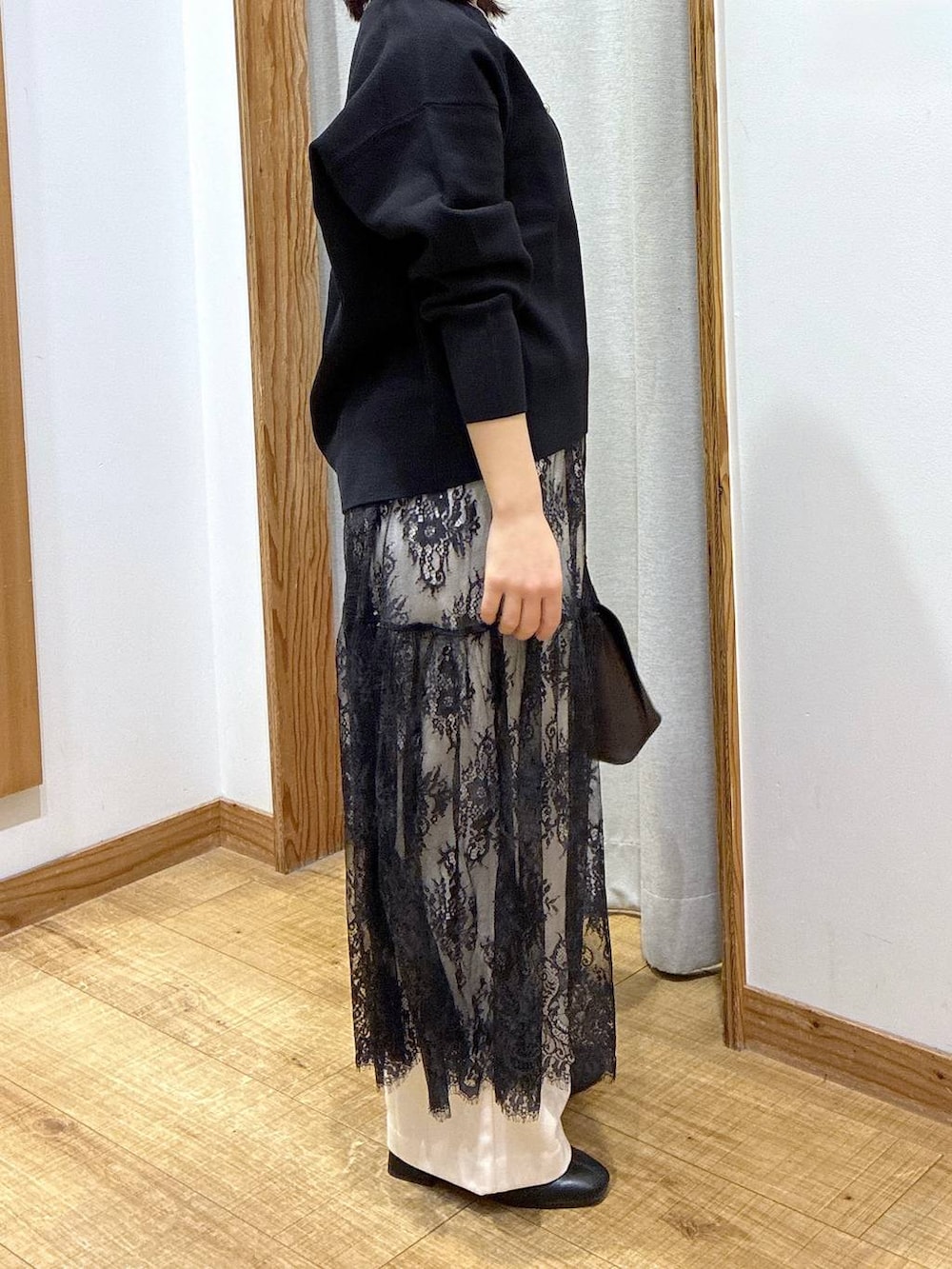 ブラウン系のショルダーバッグ、ブラック系のスウェット、イエロー系のワンピースを着用したレディースの冬コーディネートの2枚目の写真