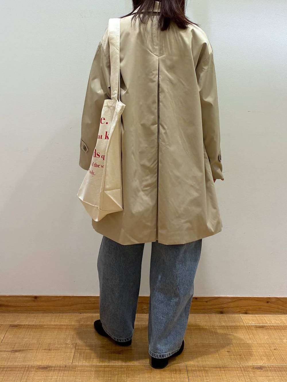 ブラック系のパンプス、ブルー系のデニムパンツ、ホワイト系のトートバッグを着用したレディースの春コーディネートの3枚目の写真