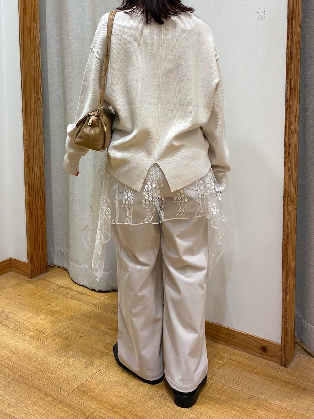 グレー系のその他パンツ、ベージュ系のショルダーバッグ、ブラウン系のブーツを着用したレディースの冬コーディネートの3枚目の写真