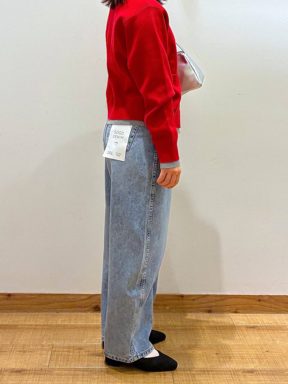 ブラック系のパンプス、ブルー系のデニムパンツ、ホワイト系のトートバッグを着用したレディースの春コーディネートの5枚目の写真