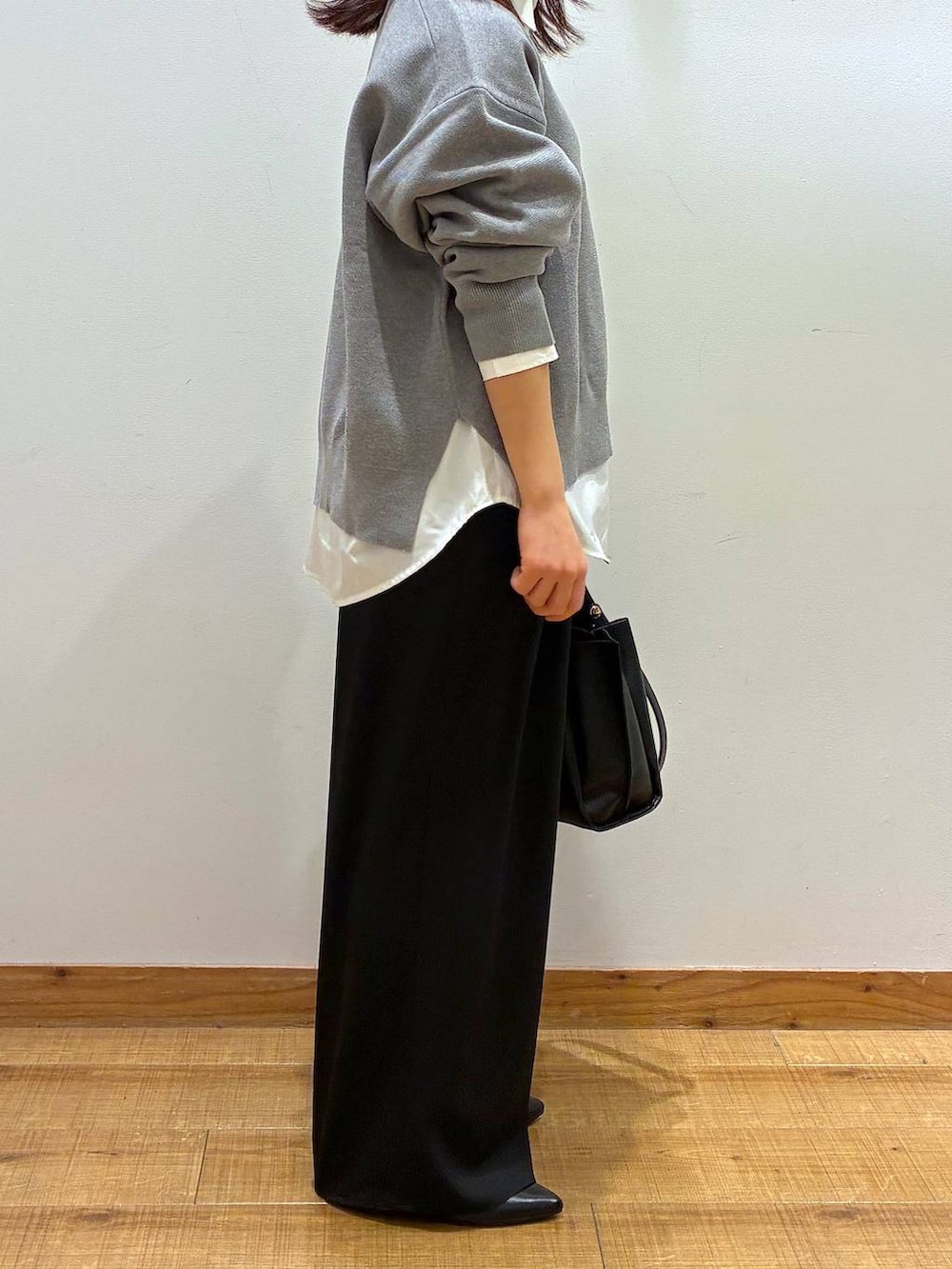 ホワイト系のシャツ/ブラウス、ブラック系のパンプス、グレー系のニット/セーターを着用したレディースの春コーディネートの2枚目の写真