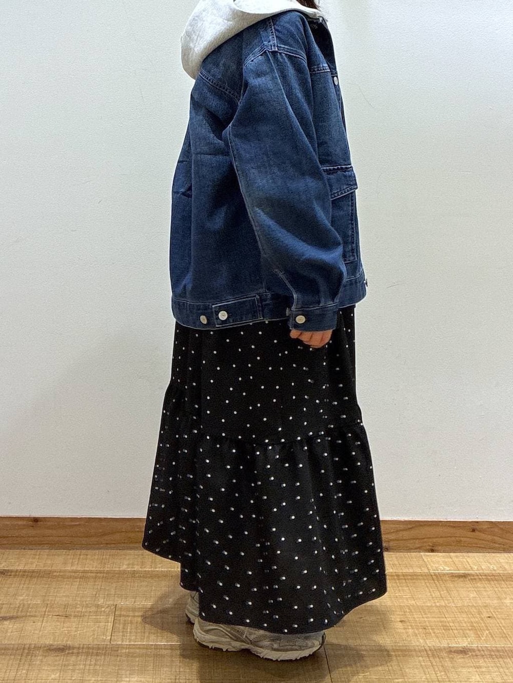 グレー系のショルダーバッグ、グレー系のパーカー、ブルー系のデニムジャケットを着用したレディースの冬コーディネートの3枚目の写真