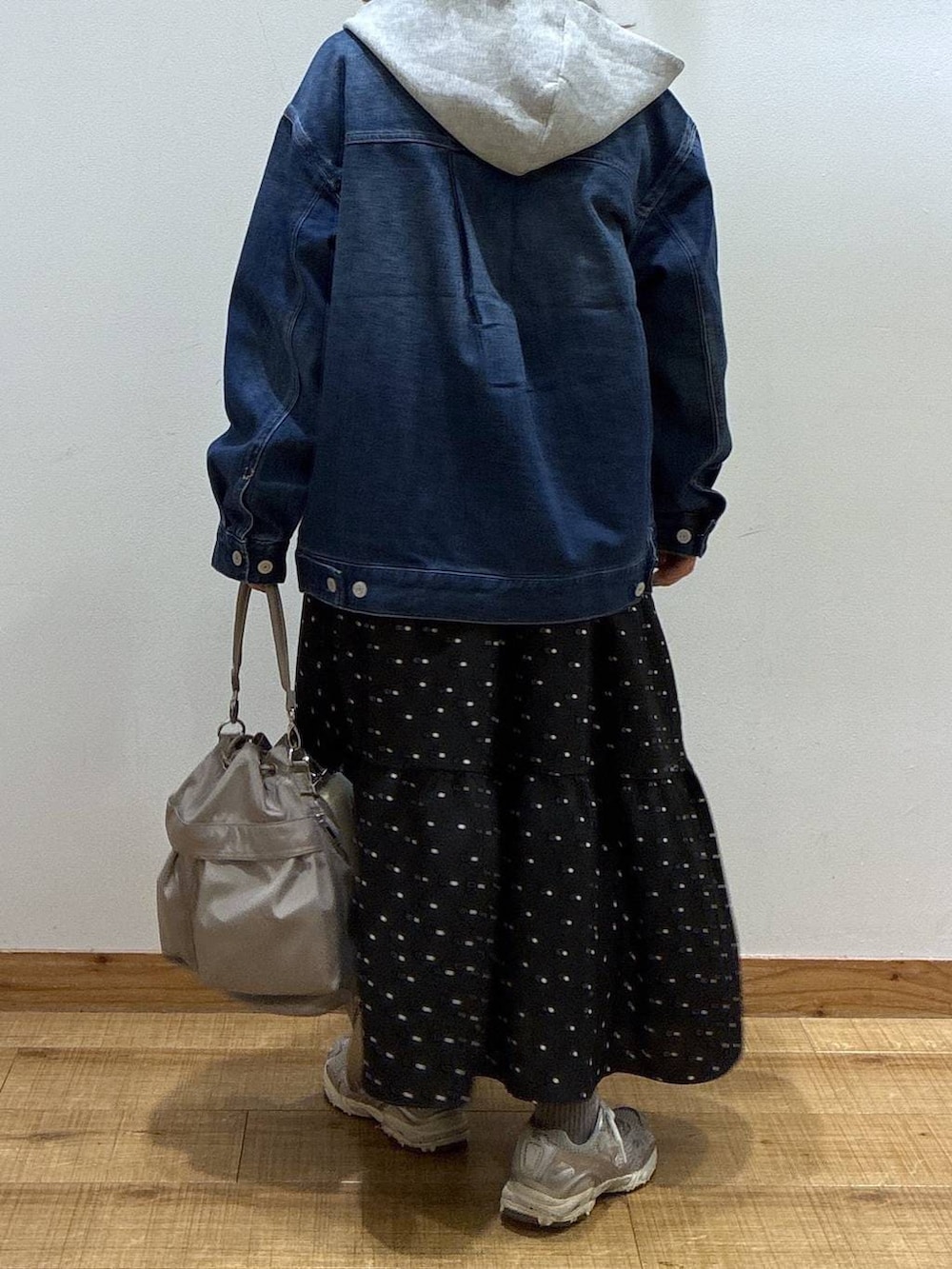 グレー系のショルダーバッグ、グレー系のパーカー、ブルー系のデニムジャケットを着用したレディースの冬コーディネートの2枚目の写真