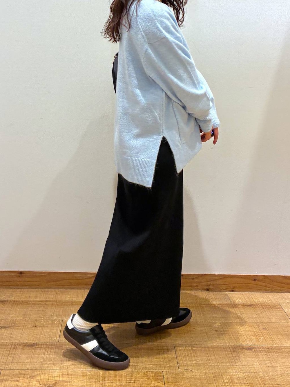 ブラック系のスニーカー、ブルー系のカーディガン/ボレロ、ホワイト系のTシャツ/カットソーを着用したレディースの秋コーディネートの2枚目の写真