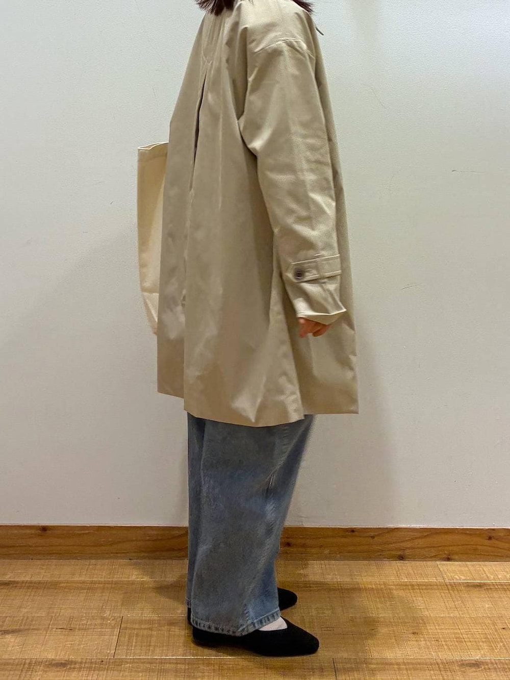 ブラック系のパンプス、ブルー系のデニムパンツ、ホワイト系のトートバッグを着用したレディースの春コーディネートの2枚目の写真