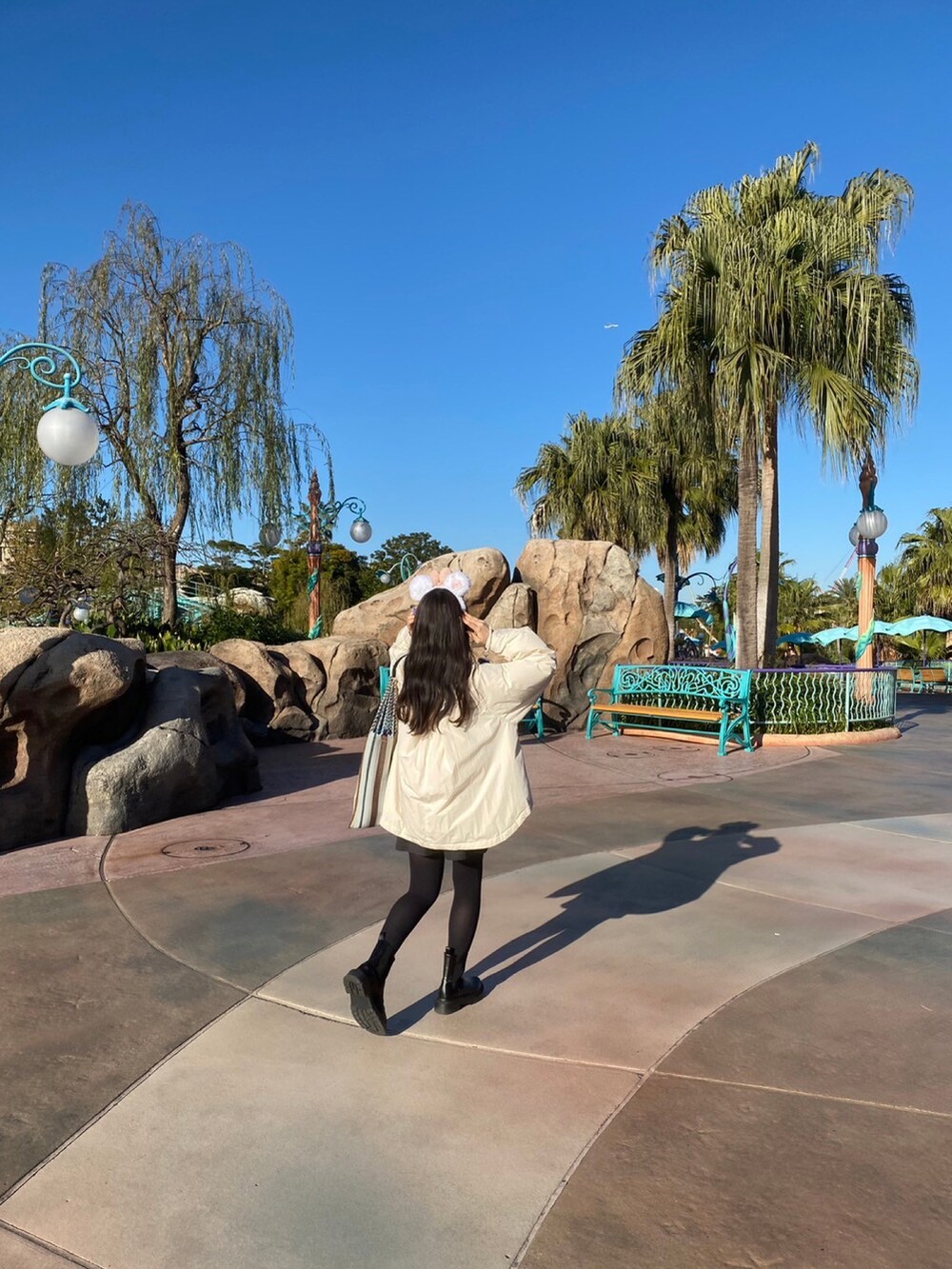 ブラック系のブーツ、グレー系のその他パンツ、ホワイト系のダウンジャケット/コートを着用したレディースの冬コーディネートの2枚目の写真