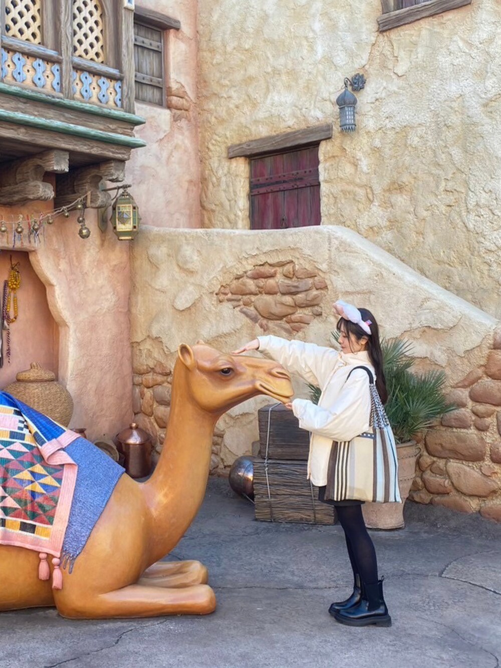 ブラック系のブーツ、グレー系のその他パンツ、ホワイト系のダウンジャケット/コートを着用したレディースの冬コーディネートの3枚目の写真