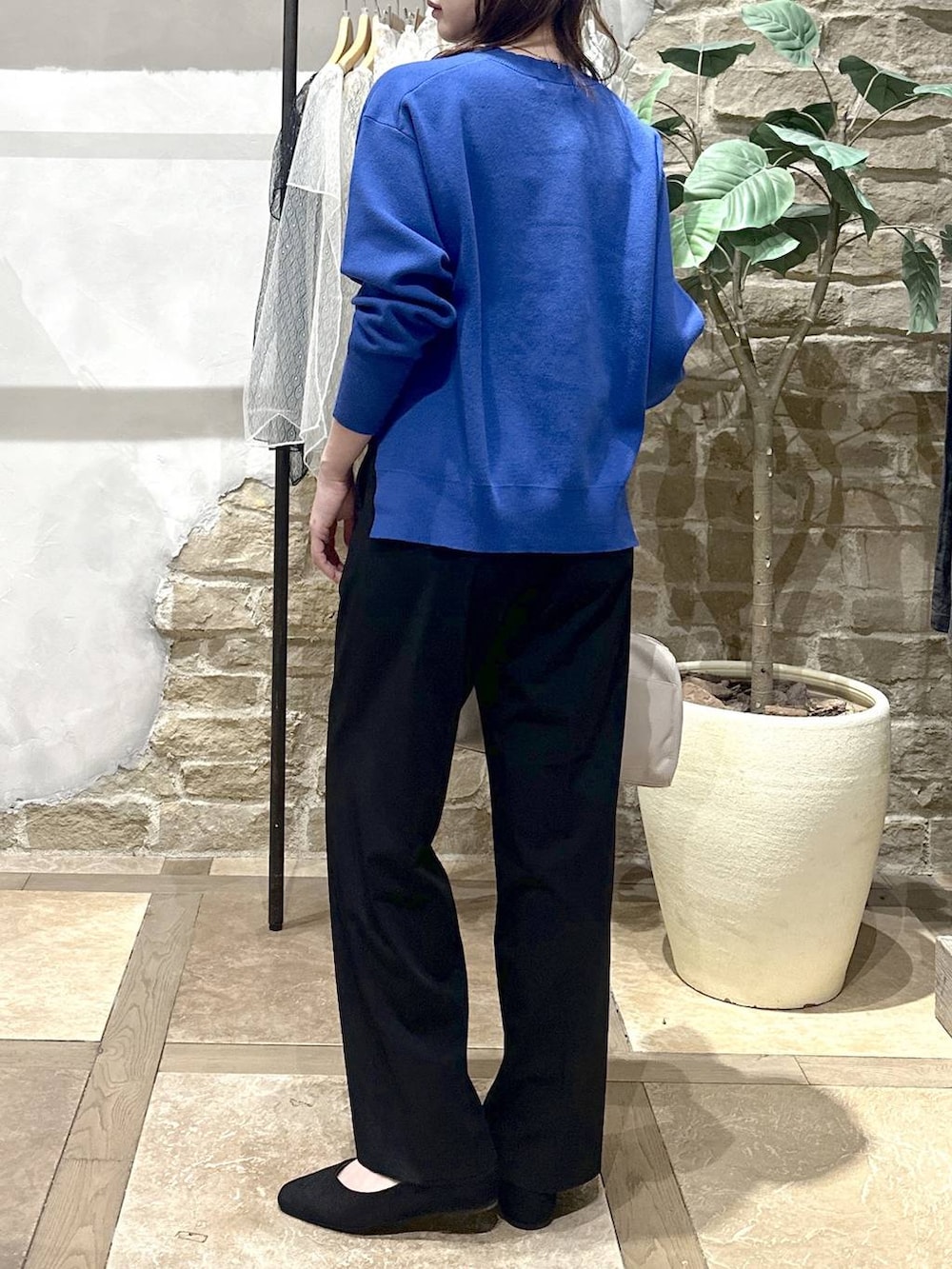 ブラック系のパンプス、ブラック系のスラックス、ブルー系のニット/セーターを着用したレディースの春コーディネートの3枚目の写真