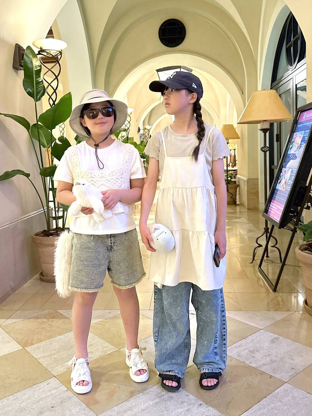 ベージュ系のチュニック、グレー系のデニムパンツ、ブラウン系のデニムパンツを着用したキッズの夏コーディネートの2枚目の写真