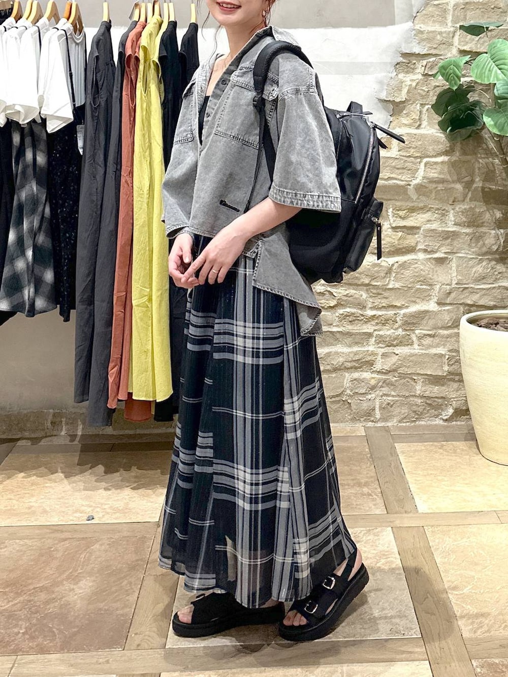 ブルー系のスカート、ブラック系のバックパック/リュック、グレー系のシャツ/ブラウスを着用したレディースの春コーディネートの3枚目の写真
