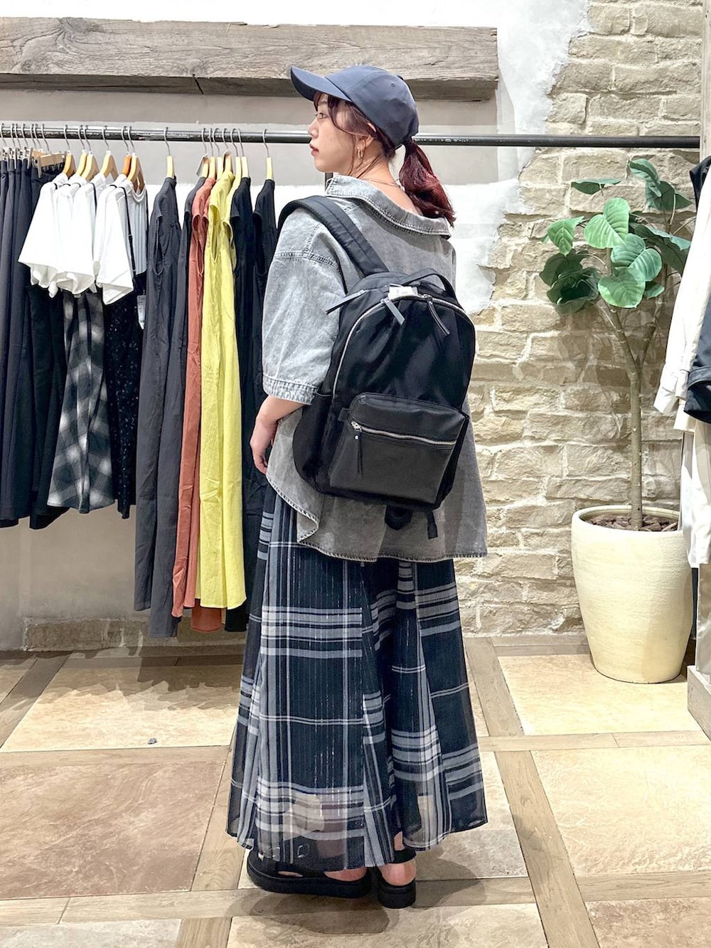 ブルー系のスカート、ブラック系のバックパック/リュック、グレー系のシャツ/ブラウスを着用したレディースの春コーディネートの4枚目の写真