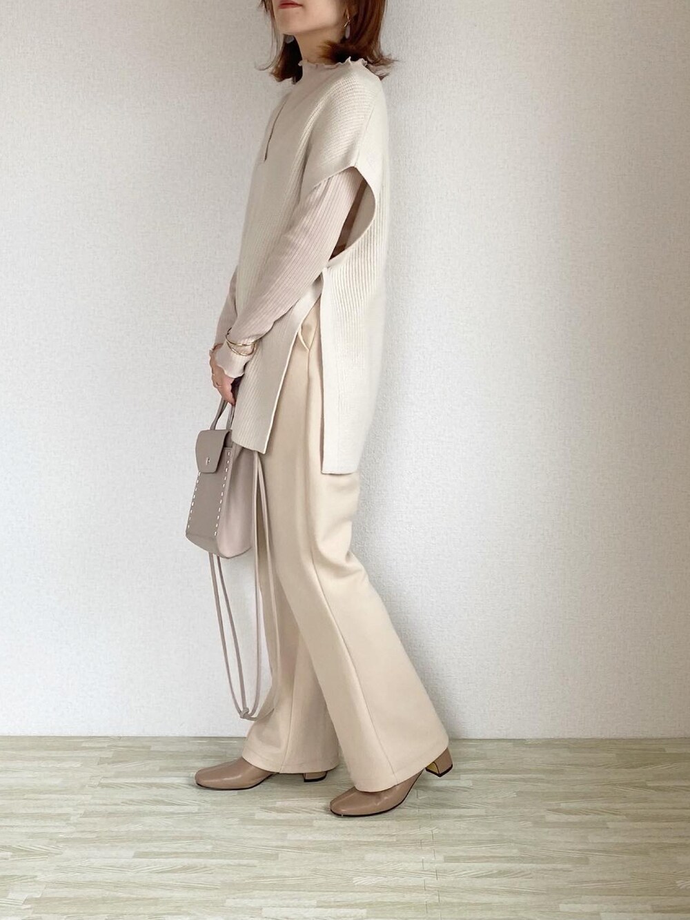 ベージュ系のバッグ、ホワイト系のその他パンツ、ベージュ系のブーツを着用したレディースの秋コーディネートの2枚目の写真