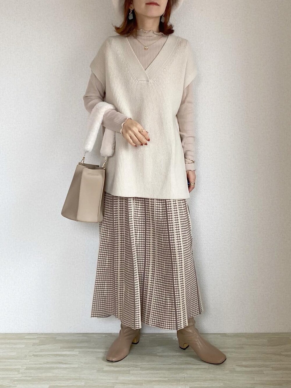 ベージュ系のジャケット/アウター、ベージュ系のバッグ、ホワイト系のベストを着用したレディースの秋コーディネートの3枚目の写真