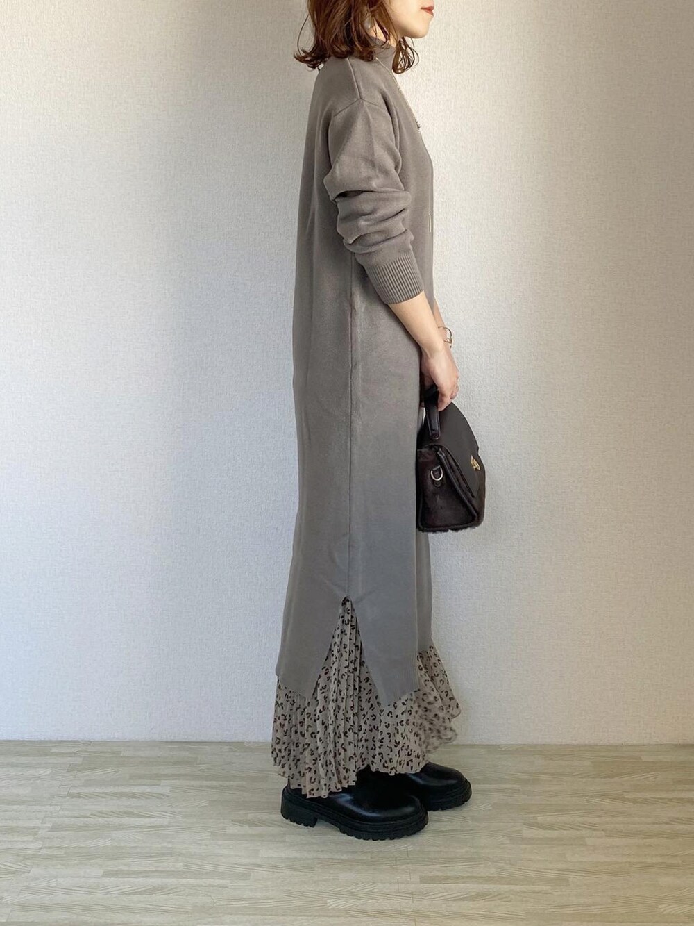 ブラック系のショルダーバッグ、グリーン系のワンピース、その他のスカートを着用したレディースの秋コーディネートの2枚目の写真