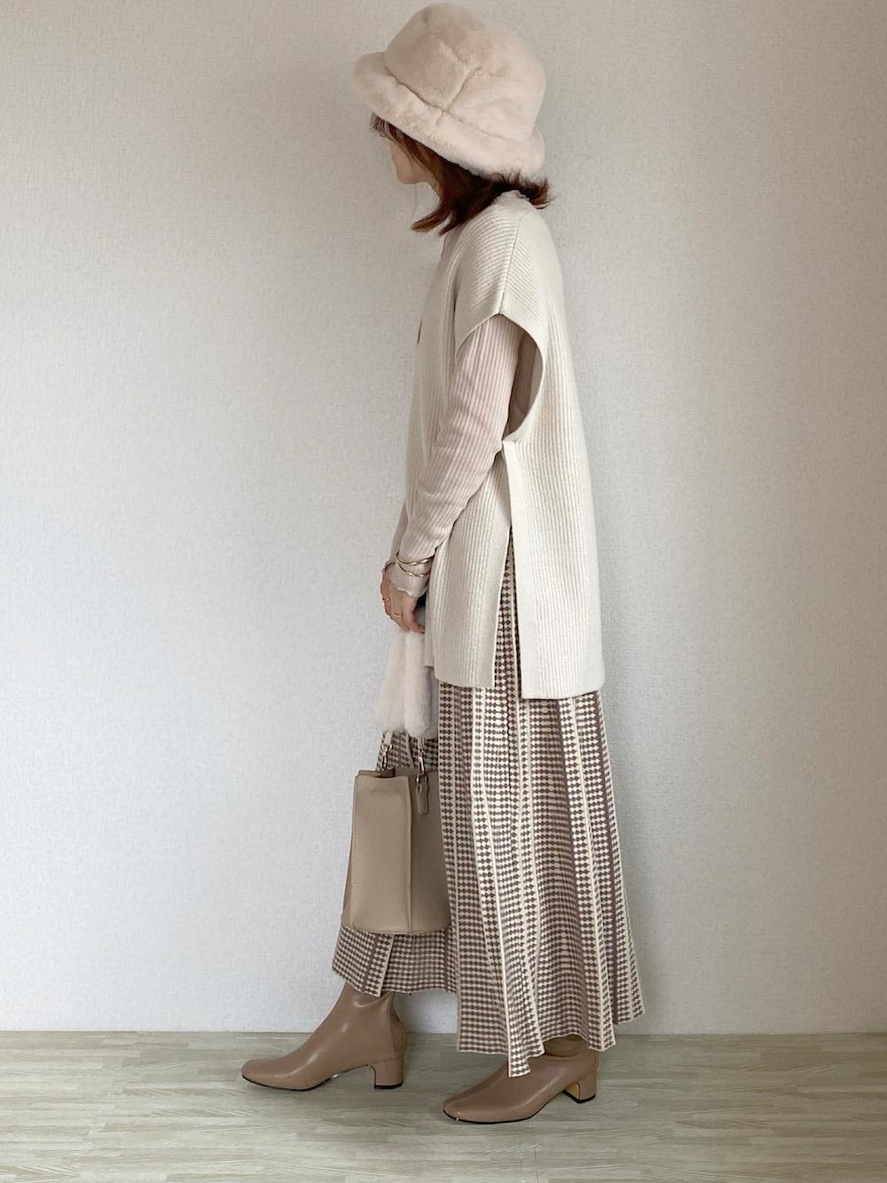 ベージュ系のジャケット/アウター、ベージュ系のバッグ、ホワイト系のベストを着用したレディースの秋コーディネートの2枚目の写真