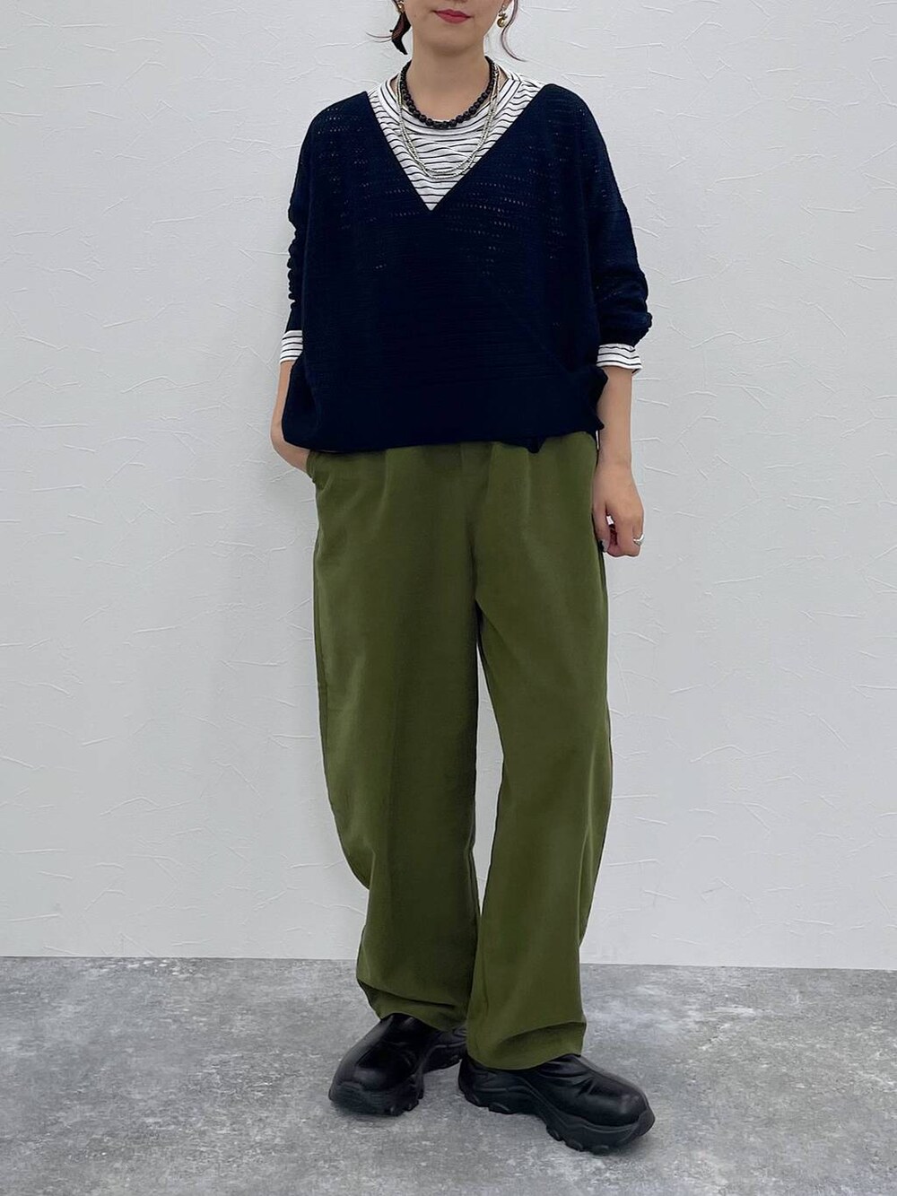 グリーン系のその他パンツ、ブラック系のブーツ、その他のTシャツ/カットソーを着用したレディースの秋コーディネートの5枚目の写真