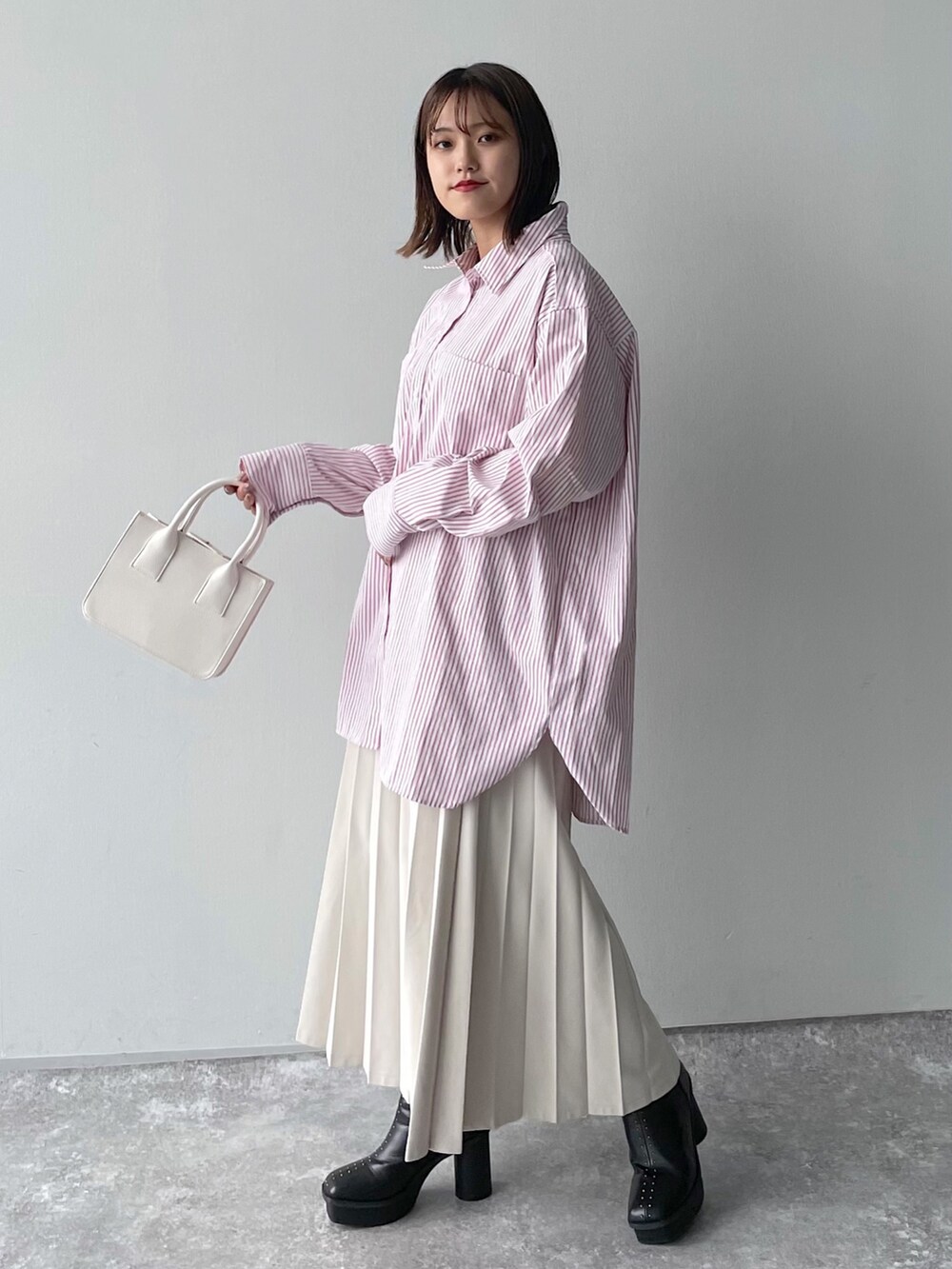 ピンク系のシャツ/ブラウス、ブラック系のバッグ、ホワイト系のスカートを着用したレディースの冬コーディネートの6枚目の写真