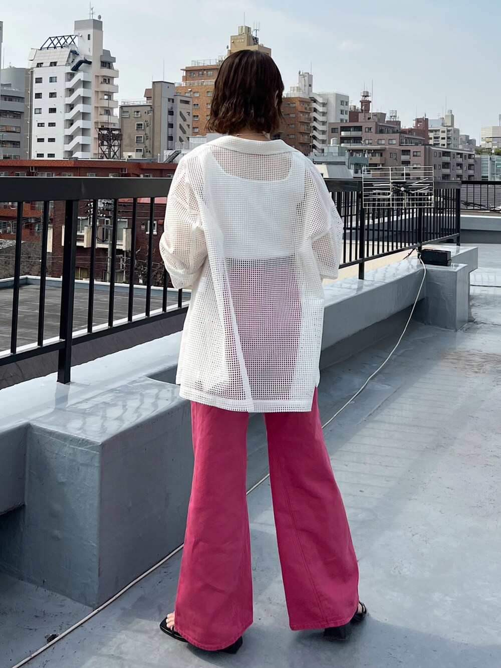 ピンク系のデニムパンツ、ホワイト系のテーラードジャケット、ホワイト系のタンクトップを着用したレディースの春コーディネートの4枚目の写真