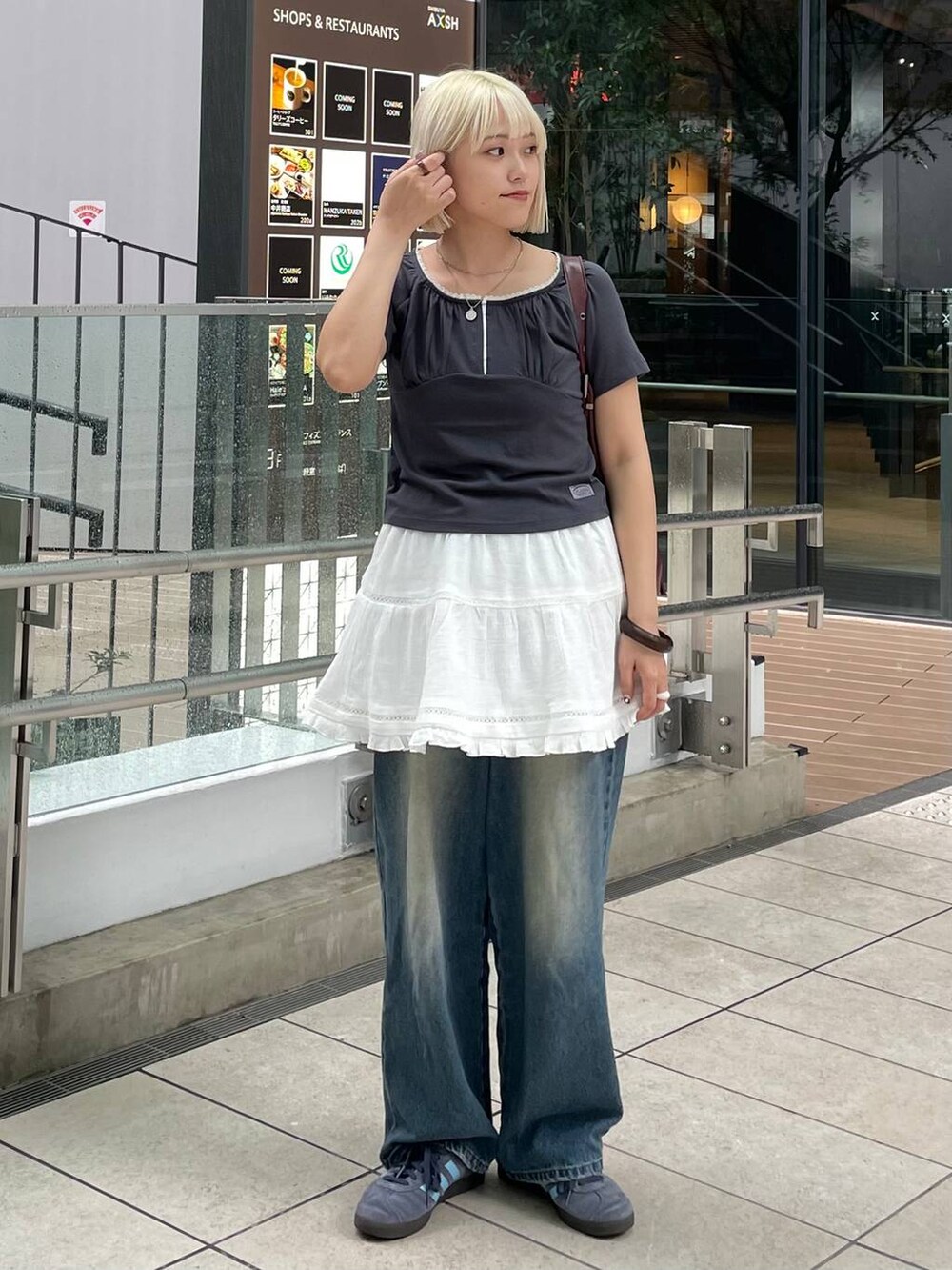 グレー系のTシャツ/カットソー、ホワイト系のスカート、レッド系のショルダーバッグを着用したレディースの秋コーディネートの4枚目の写真