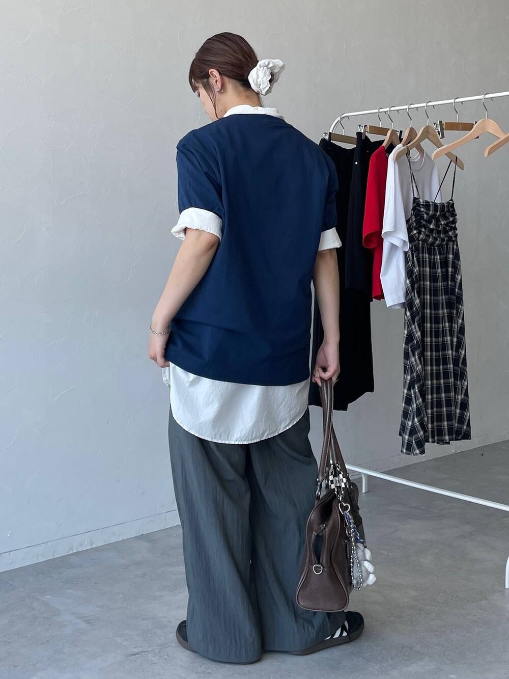 ブラウン系のボストンバッグ、ホワイト系のシャツ/ブラウス、グレー系のその他パンツを着用したレディースの夏コーディネートの3枚目の写真