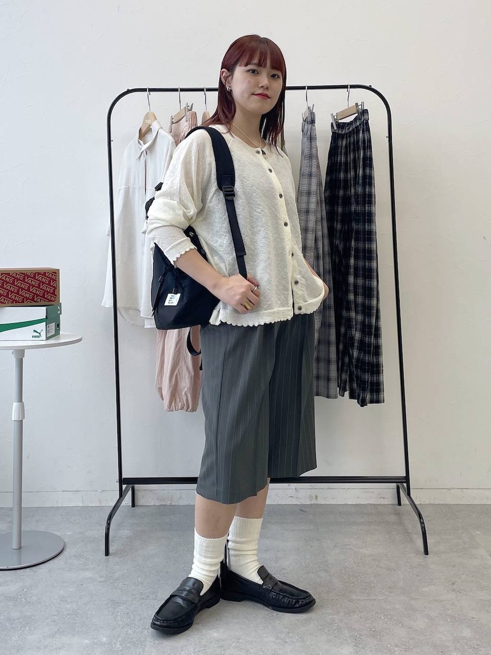 ブラック系のローファー、ブラック系のバックパック/リュック、グレー系のスラックスを着用したレディースの春コーディネートの7枚目の写真