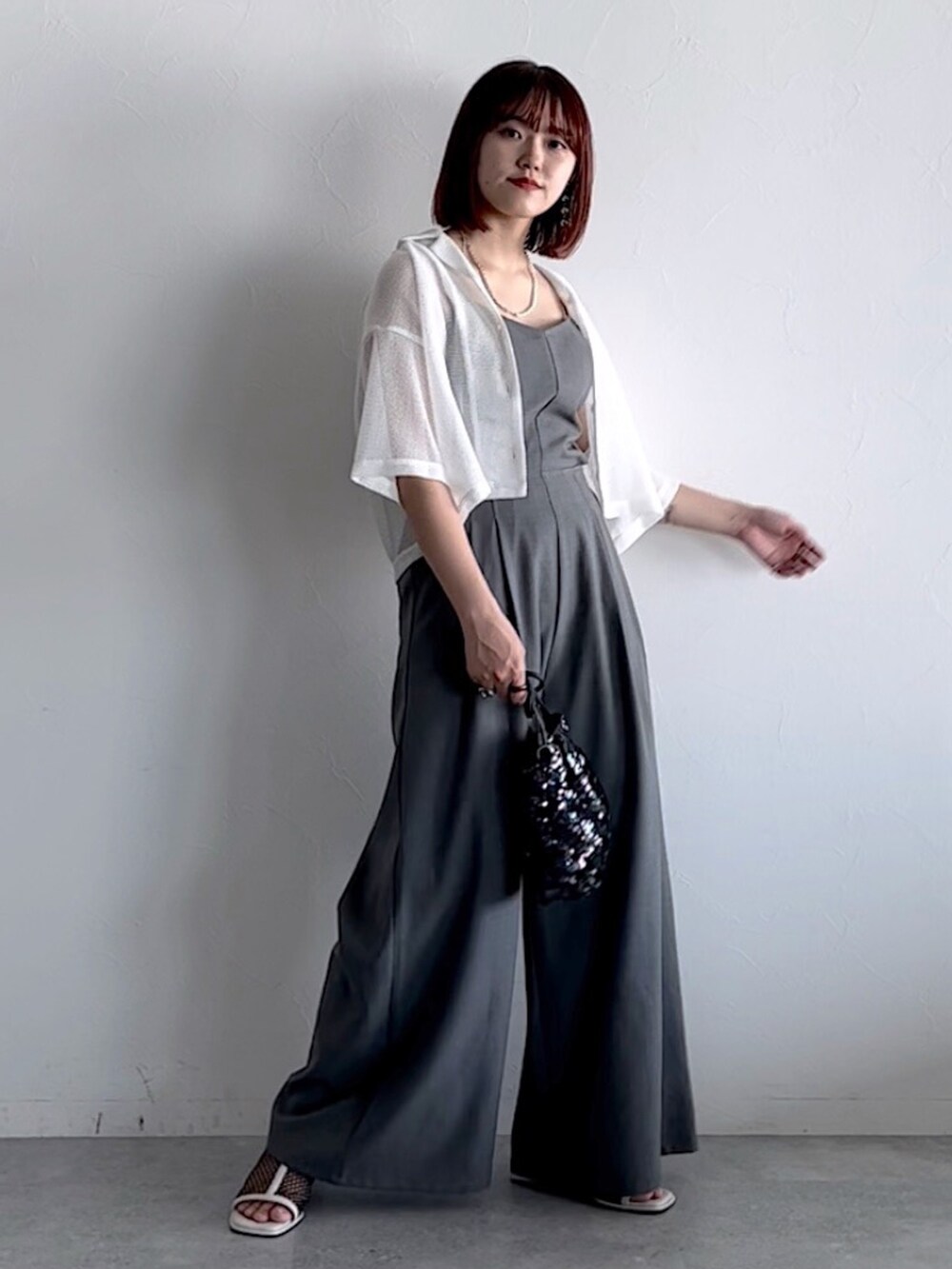 ホワイト系のシャツ/ブラウス、ブラック系のショルダーバッグ、ホワイト系のサンダルを着用したレディースの春コーディネートの2枚目の写真