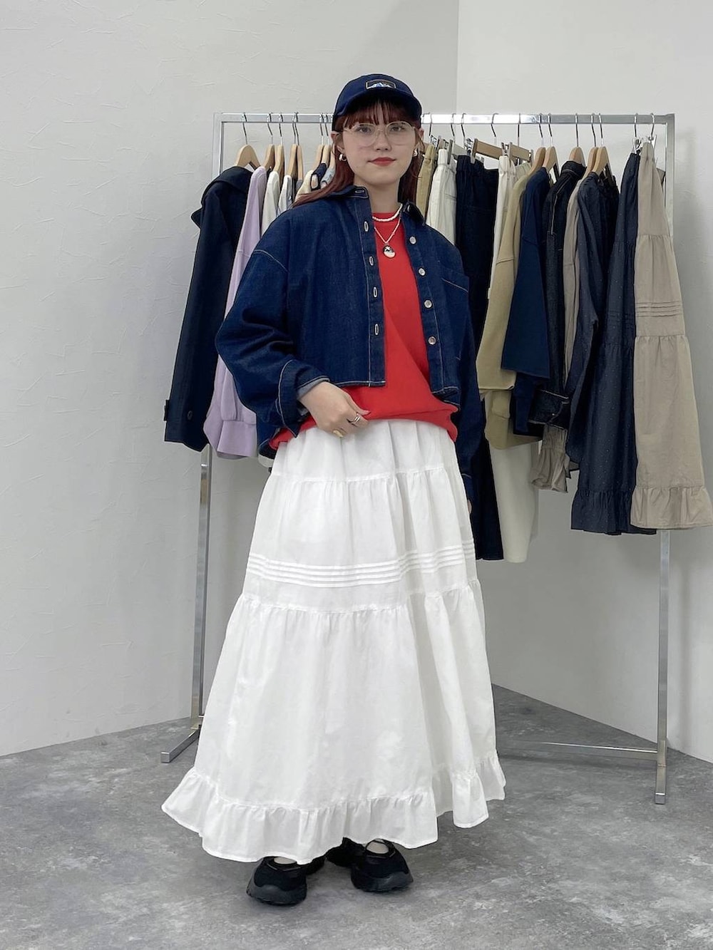 ブラック系のスニーカー、レッド系のスウェット、ホワイト系のスカートを着用したレディースの春コーディネートの7枚目の写真