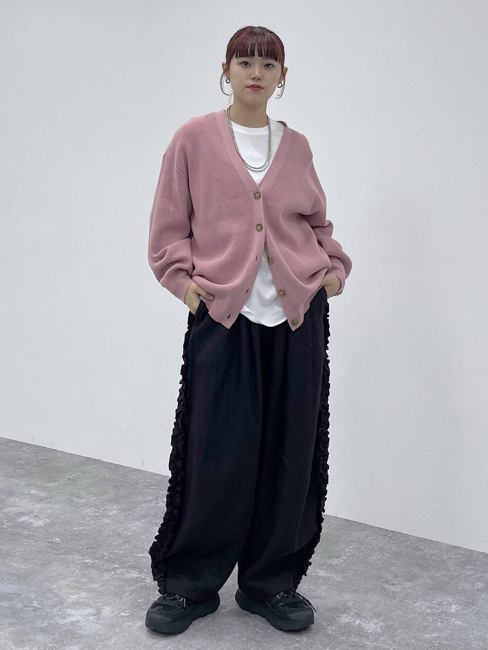 ホワイト系のTシャツ/カットソー、ピンク系のカーディガン/ボレロ、ブラック系のその他パンツを着用したレディースの秋コーディネートの6枚目の写真