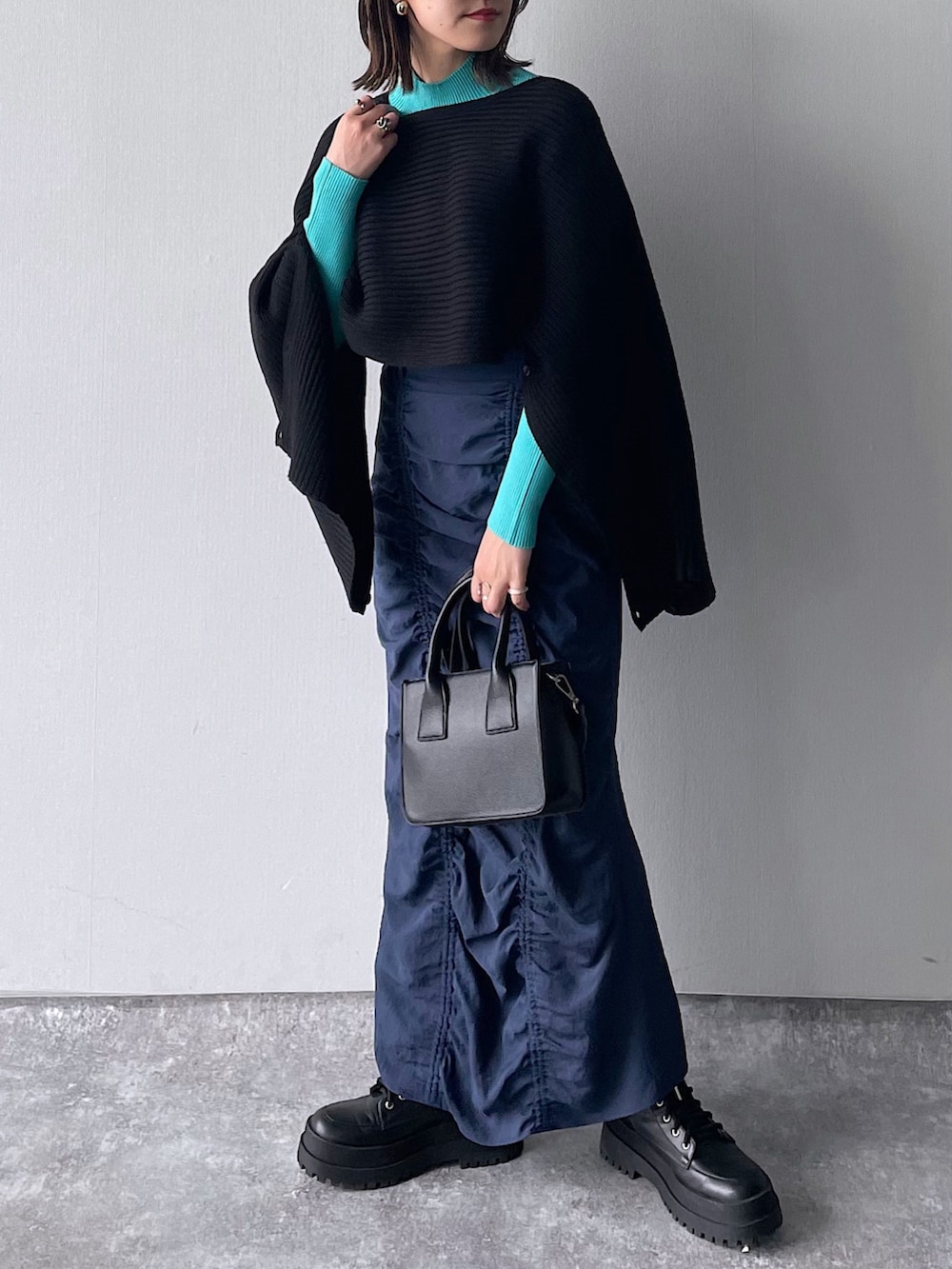 ブラック系のワンピース、ブルー系のニット/セーター、ブラック系のショルダーバッグを着用したレディースの冬コーディネートの3枚目の写真