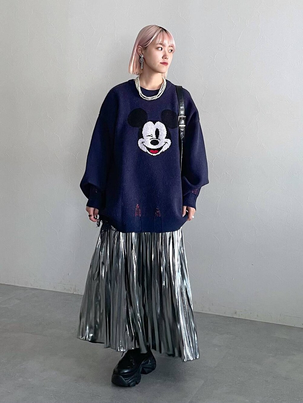 ブラック系のブーツ、ブラック系のショルダーバッグ、グレー系のスカートを着用したレディースの秋コーディネートの4枚目の写真