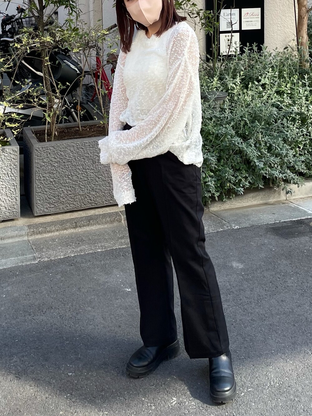 ホワイト系のタンクトップ、ブラック系のスラックス、ホワイト系のバッグを着用したレディースの春コーディネートの2枚目の写真