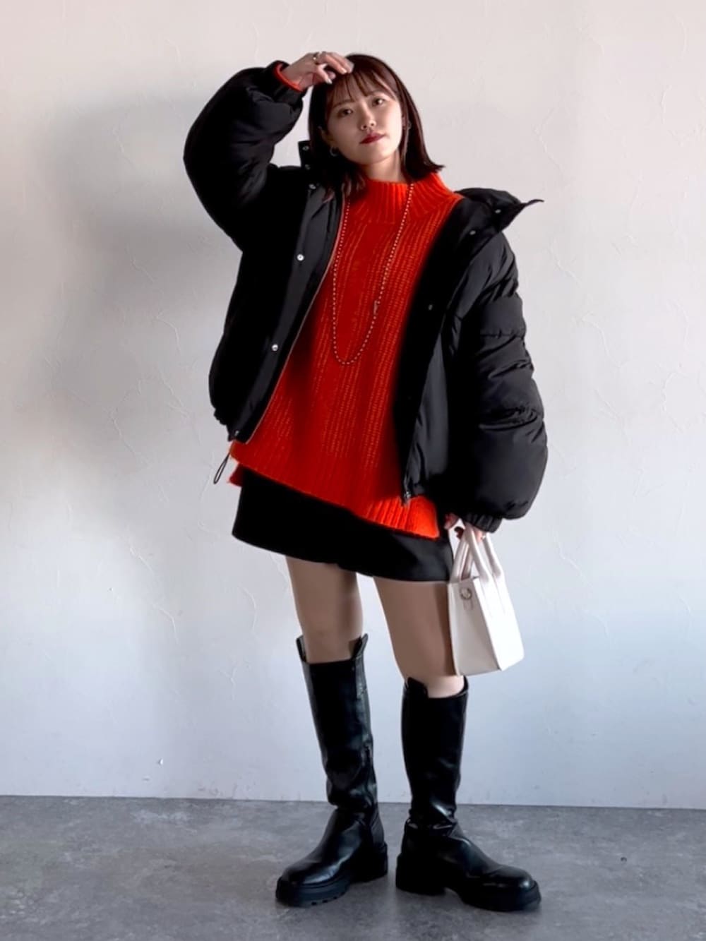 オレンジ系のニット/セーター、ブラック系のブルゾン、ブラック系のその他パンツを着用したレディースの冬コーディネートの8枚目の写真