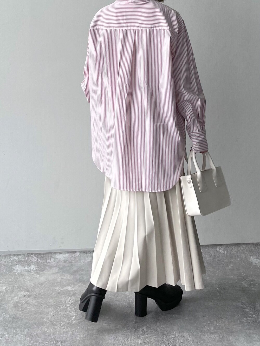 ピンク系のシャツ/ブラウス、ブラック系のバッグ、ホワイト系のスカートを着用したレディースの冬コーディネートの2枚目の写真