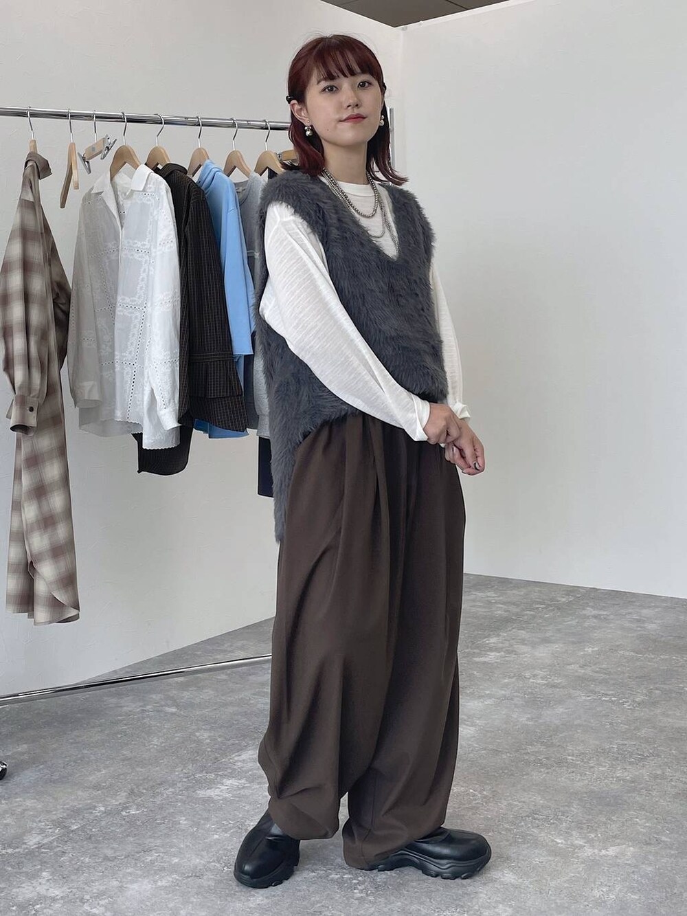 ブラウン系のその他パンツ、ブラック系のブーツ、ホワイト系のTシャツ/カットソーを着用したレディースの秋コーディネートの5枚目の写真